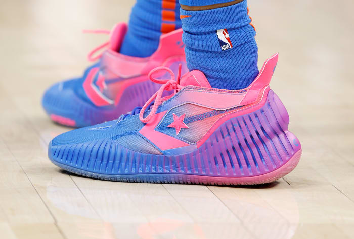 View of pink and purple Converse shoes.